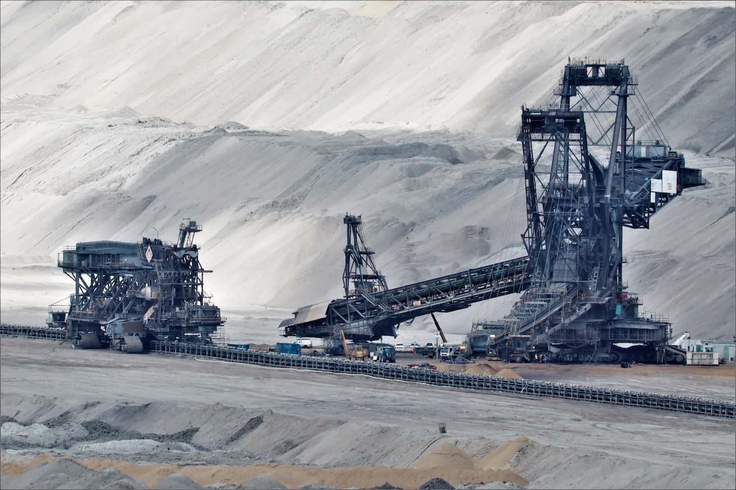 Industrial equipment across a pale extraction landscape.