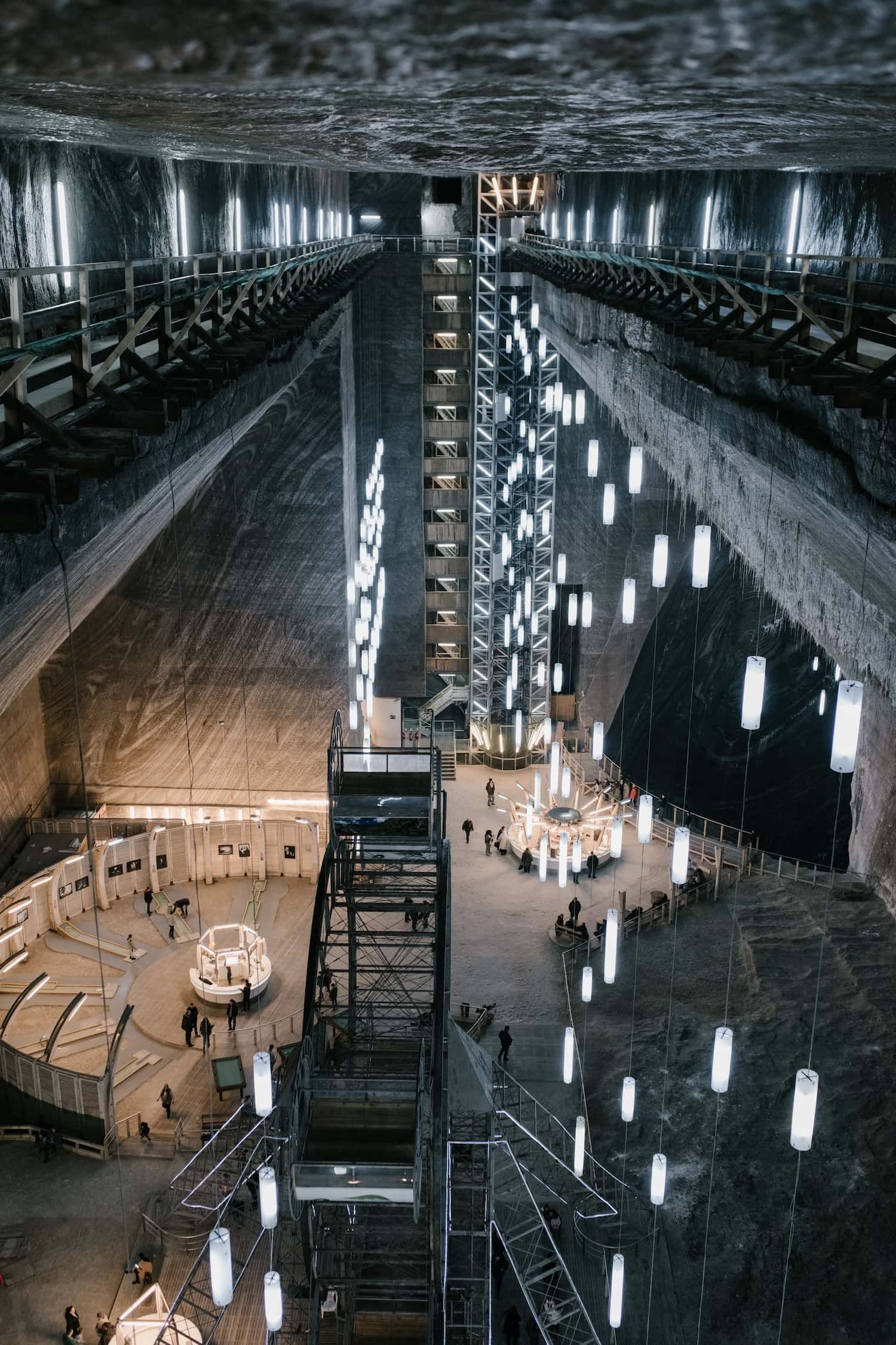 People moving through an illuminated underground public space.